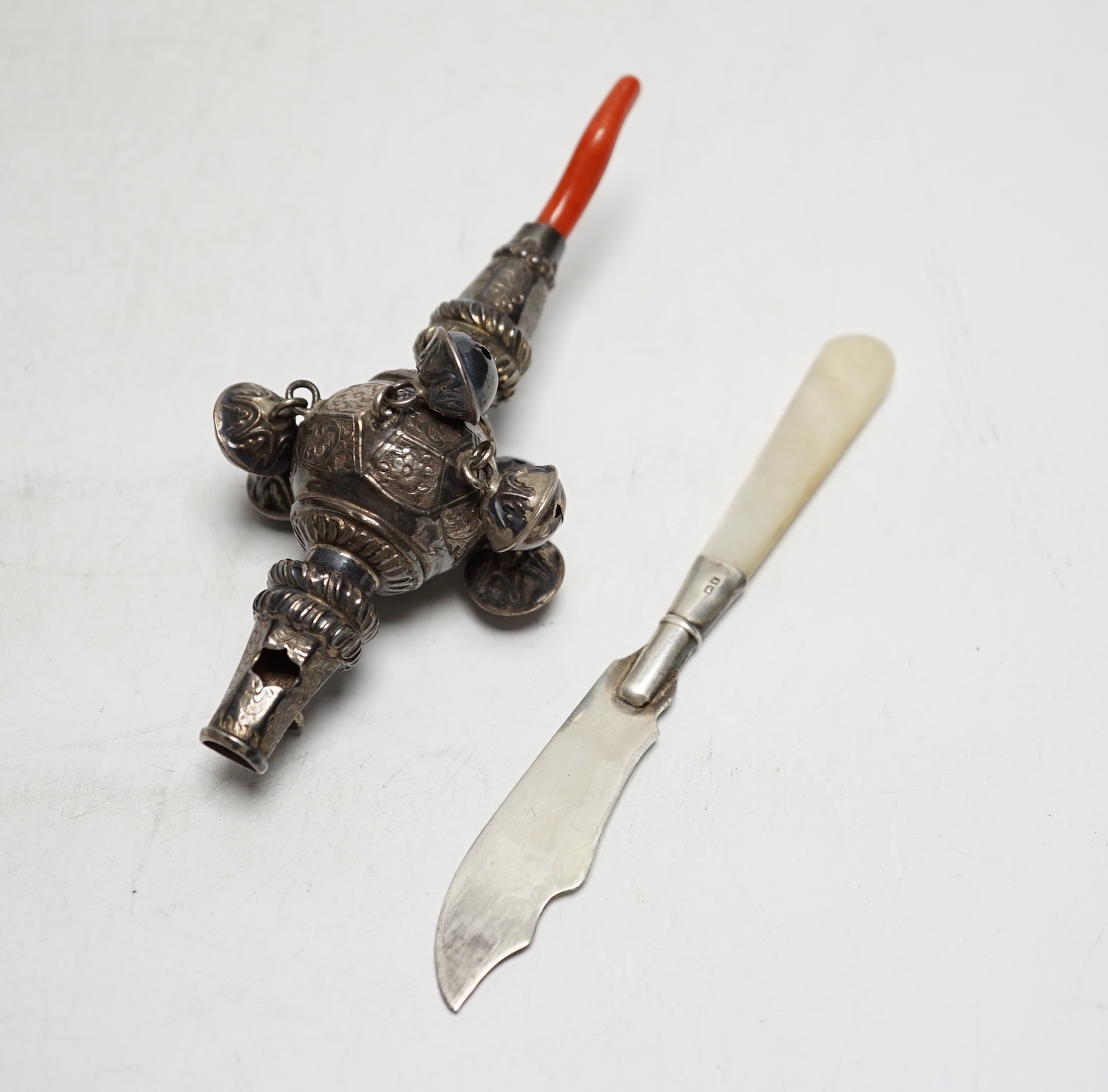 A late Victorian silver baby rattle, with coral teether, by George Unite, 11.6cm and a small silver butter knife.